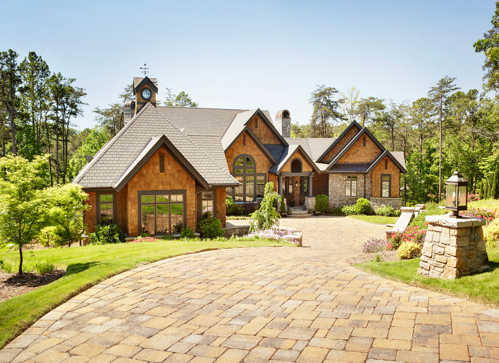 Large and brown rustic house exterior in Other with wood cladding and a pitched roof.