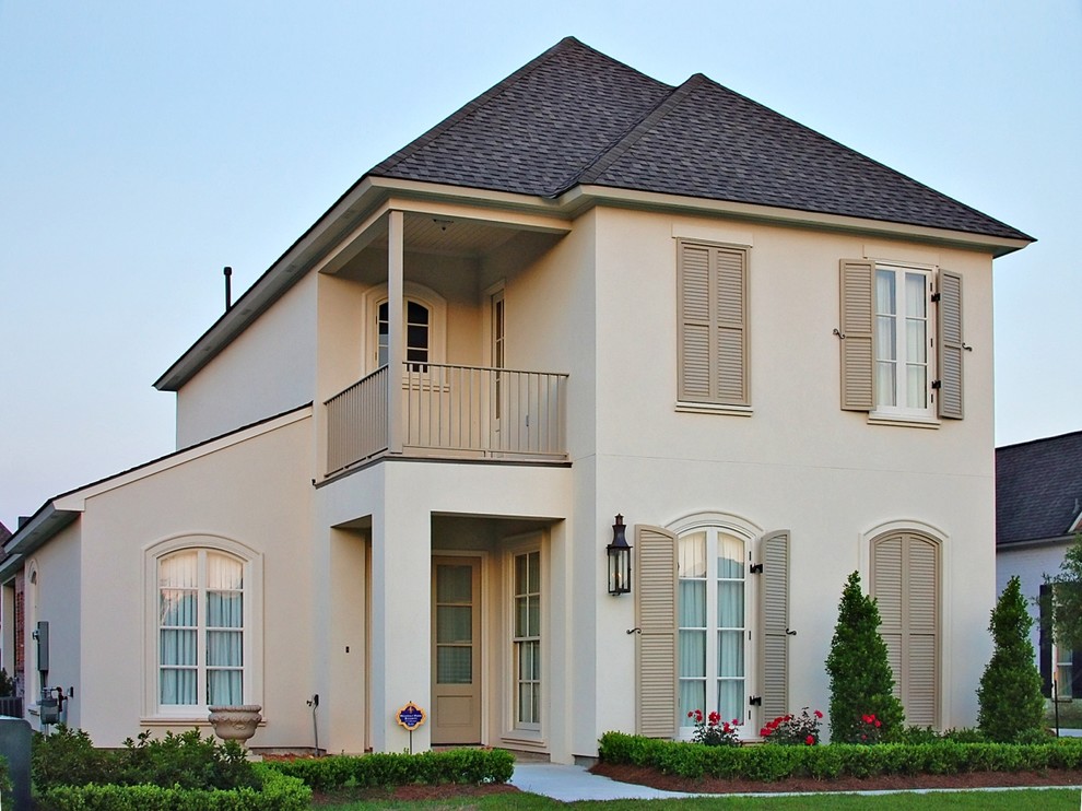 Esempio della villa grande beige classica a due piani con rivestimento in mattoni, tetto a padiglione e copertura a scandole