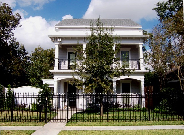 Medium sized and white victorian two floor house exterior in Houston with vinyl cladding.