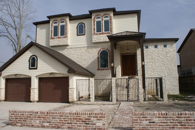 Immagine della facciata di una casa grande bianca american style a due piani con rivestimenti misti e tetto a padiglione