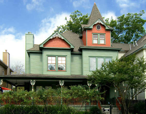 Mittelgroßes, Zweistöckiges Klassisches Haus mit Vinylfassade, grüner Fassadenfarbe und Walmdach in Houston