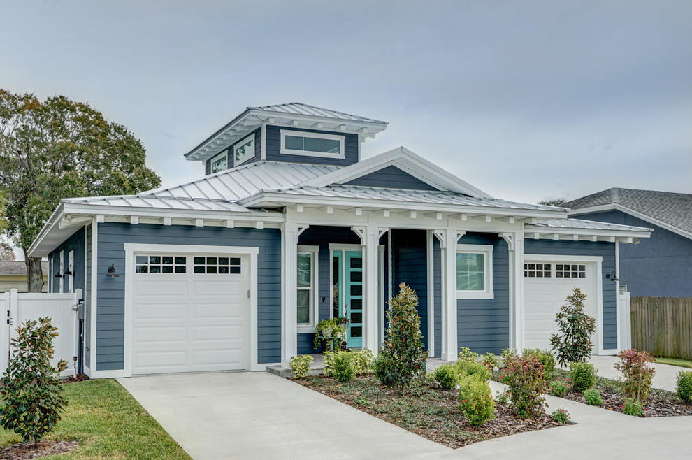 Cette image montre une façade de maison bleue marine en panneau de béton fibré de taille moyenne et de plain-pied avec un toit à deux pans et un toit en métal.