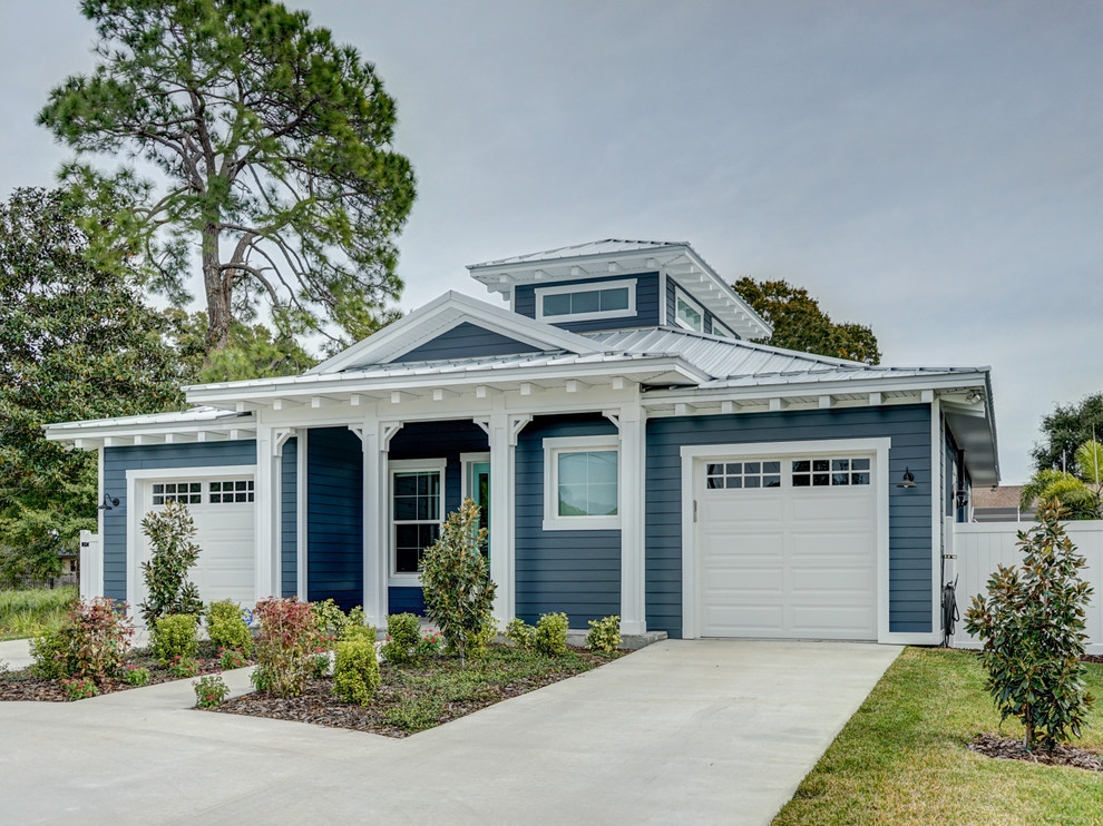 Ispirazione per la villa blu stile marinaro a un piano di medie dimensioni con rivestimento con lastre in cemento, tetto a capanna e copertura in metallo o lamiera