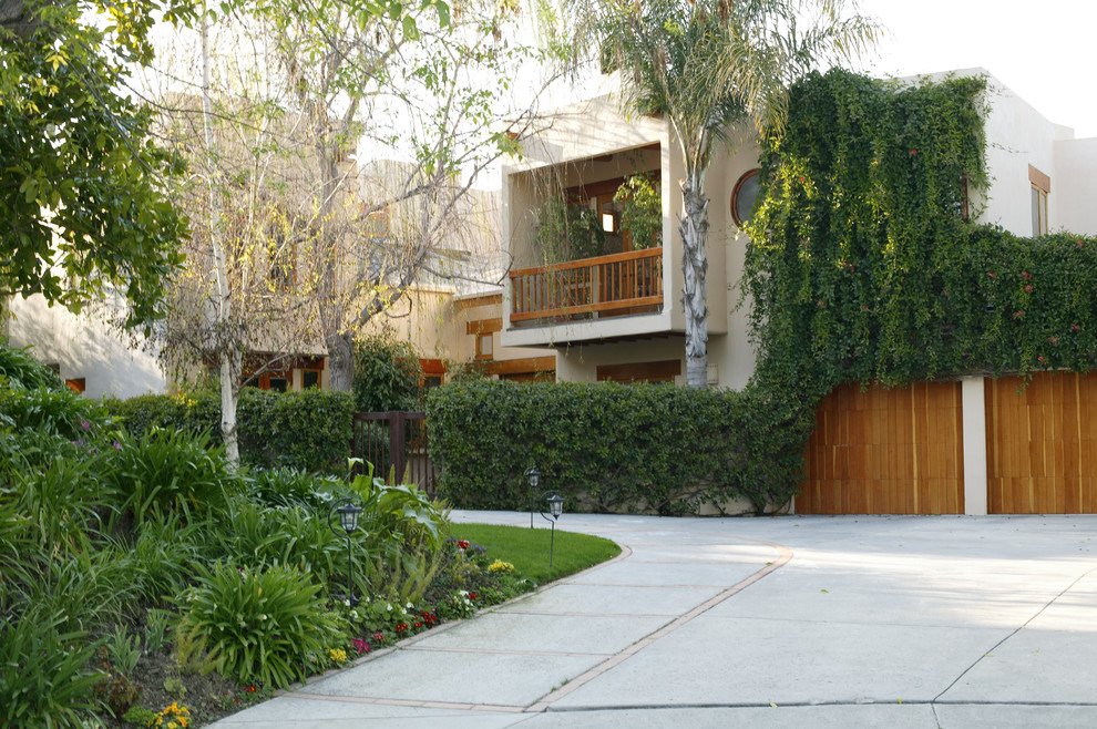 Example of a mid-sized trendy white two-story stucco exterior home design in Los Angeles