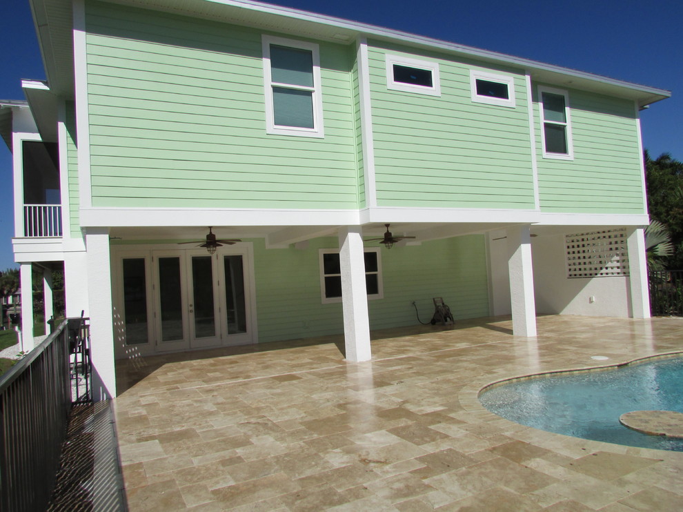 Large coastal green two-story concrete fiberboard house exterior idea in Miami with a hip roof and a metal roof
