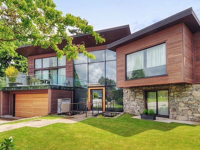 Large and brown contemporary house exterior in Ottawa with three floors and wood cladding.