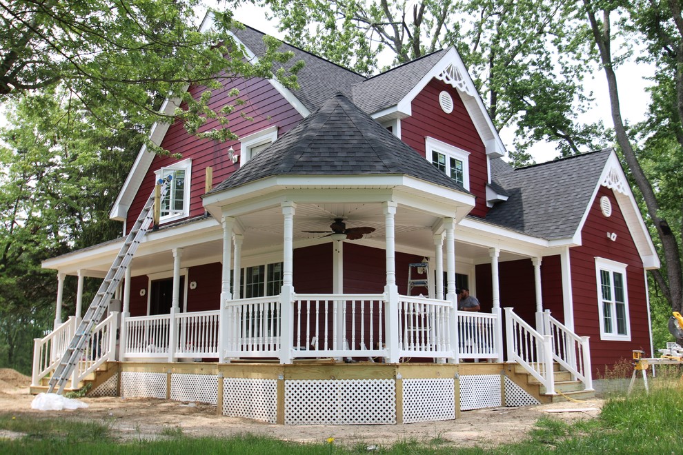 Modelo de fachada roja de estilo de casa de campo grande de dos plantas con revestimiento de hormigón y tejado a doble faldón