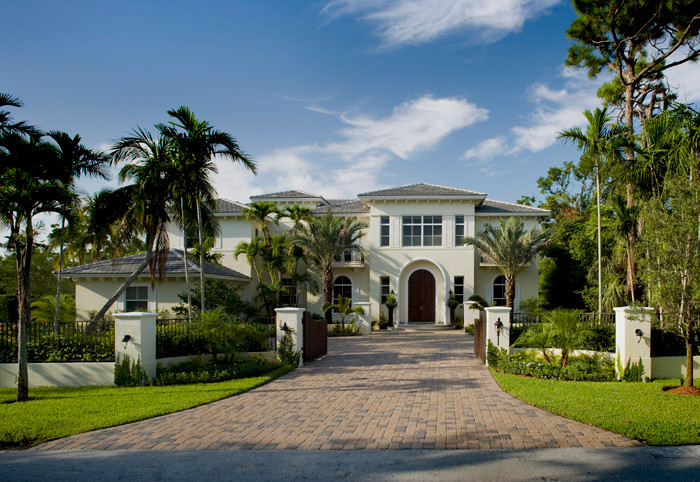 Großes, Zweistöckiges Haus mit Putzfassade, beiger Fassadenfarbe und Walmdach in Miami