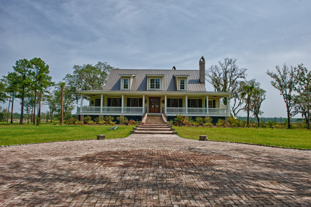 Mittelgroßes, Zweistöckiges Klassisches Haus mit gelber Fassadenfarbe und Blechdach in Charleston