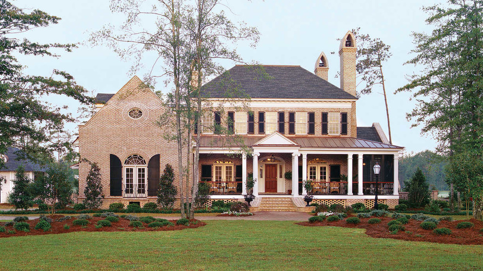 Foto della facciata di una casa rossa classica a due piani di medie dimensioni con rivestimento in mattoni