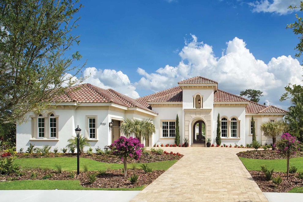 Inspiration for a large mediterranean white two-story stucco gable roof remodel in Orlando