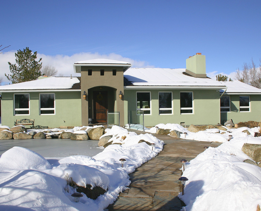 Cette image montre une façade de maison verte design en stuc de taille moyenne et de plain-pied avec un toit à quatre pans.