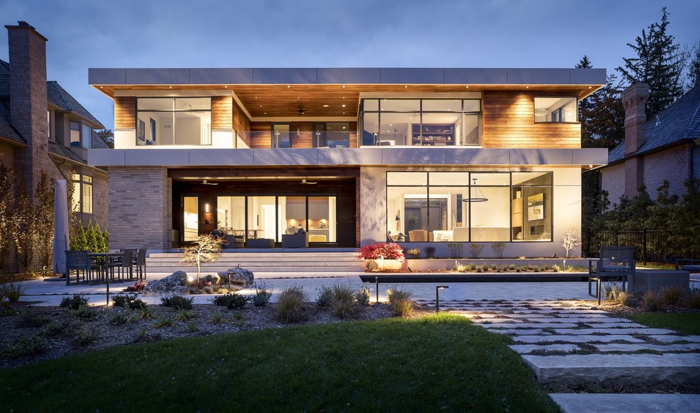 Inspiration pour une grande façade de maison multicolore design à un étage avec un revêtement mixte, un toit plat et un toit végétal.