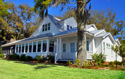 Example of a mid-sized cottage white two-story wood gable roof design in Miami