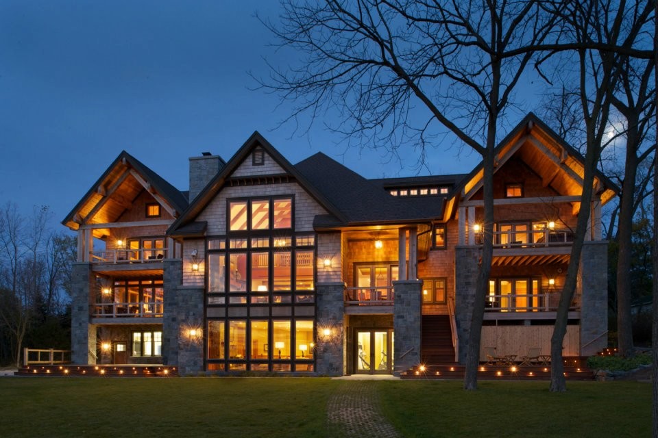 Cette photo montre une grande façade de maison beige chic à deux étages et plus avec un revêtement mixte et un toit à deux pans.