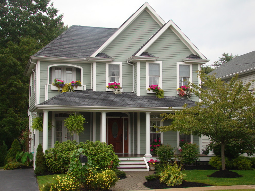 Ejemplo de fachada de casa verde clásica de tamaño medio de dos plantas con revestimiento de aglomerado de cemento, tejado a cuatro aguas y tejado de teja de madera