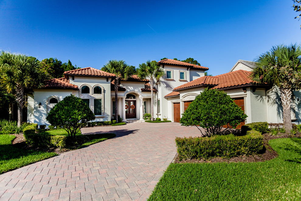 Inspiration for a large and white mediterranean two floor render house exterior in Jacksonville with a hip roof.
