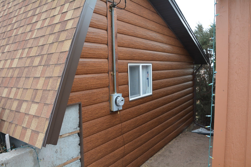 Rustik inredning av ett mellanstort brunt hus, med två våningar och metallfasad