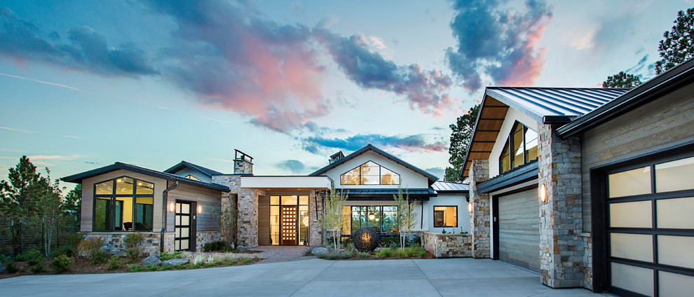 На фото: огромный, двухэтажный, разноцветный частный загородный дом в современном стиле с комбинированной облицовкой, двускатной крышей и металлической крышей с