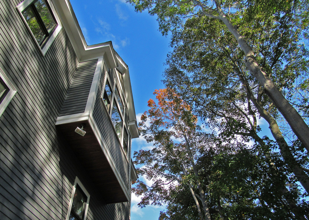 Foto della villa grande blu contemporanea a due piani con tetto a padiglione, copertura a scandole e rivestimento in legno