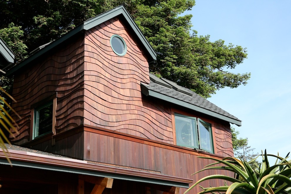Modelo de fachada marrón bohemia de tamaño medio de dos plantas con revestimiento de madera