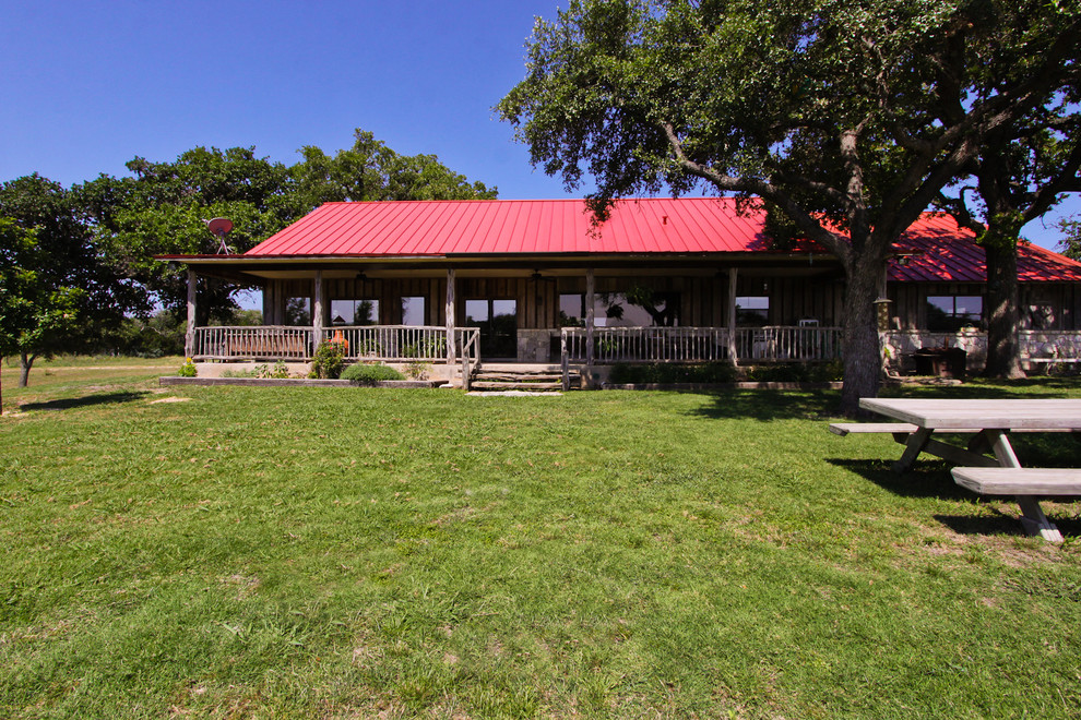 Example of a large mountain style brown one-story wood exterior home design in Austin with a clipped gable roof