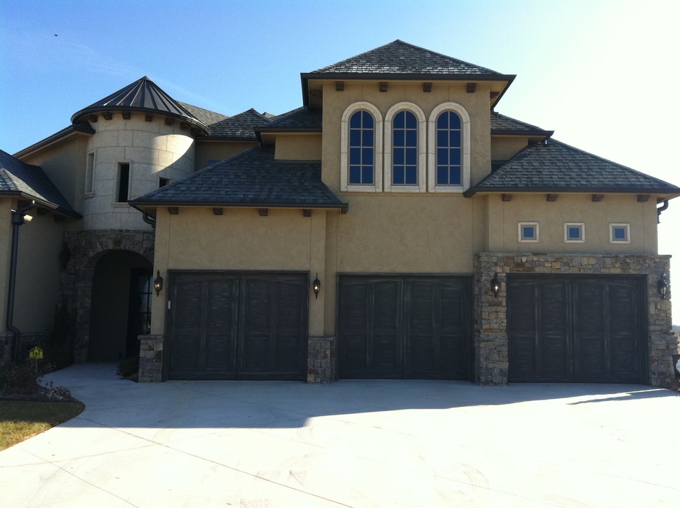 Example of a large tuscan beige two-story stucco exterior home design in Other