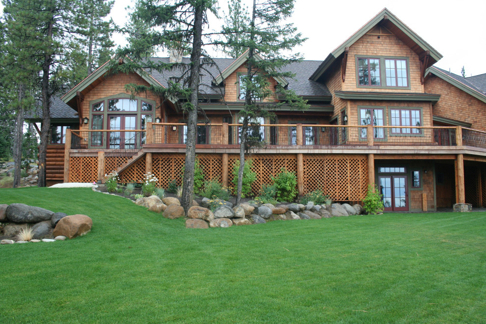 Inspiration for a large rustic brown three-story wood exterior home remodel in Other with a shingle roof