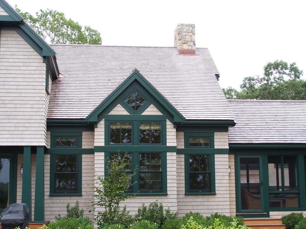 Exemple d'une grande façade de maison nature en bois à un étage avec un toit à deux pans et un toit en tuile.