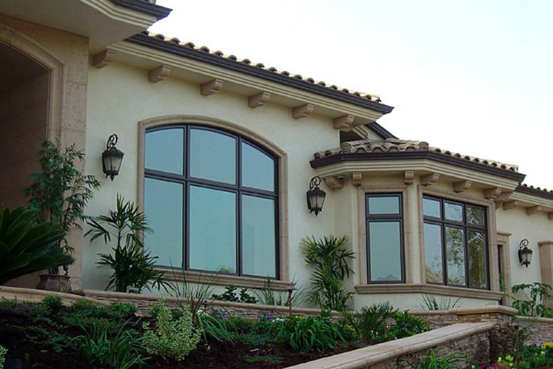 Esempio della villa grande beige mediterranea a un piano con rivestimento in stucco, tetto a padiglione, copertura in tegole e tetto marrone