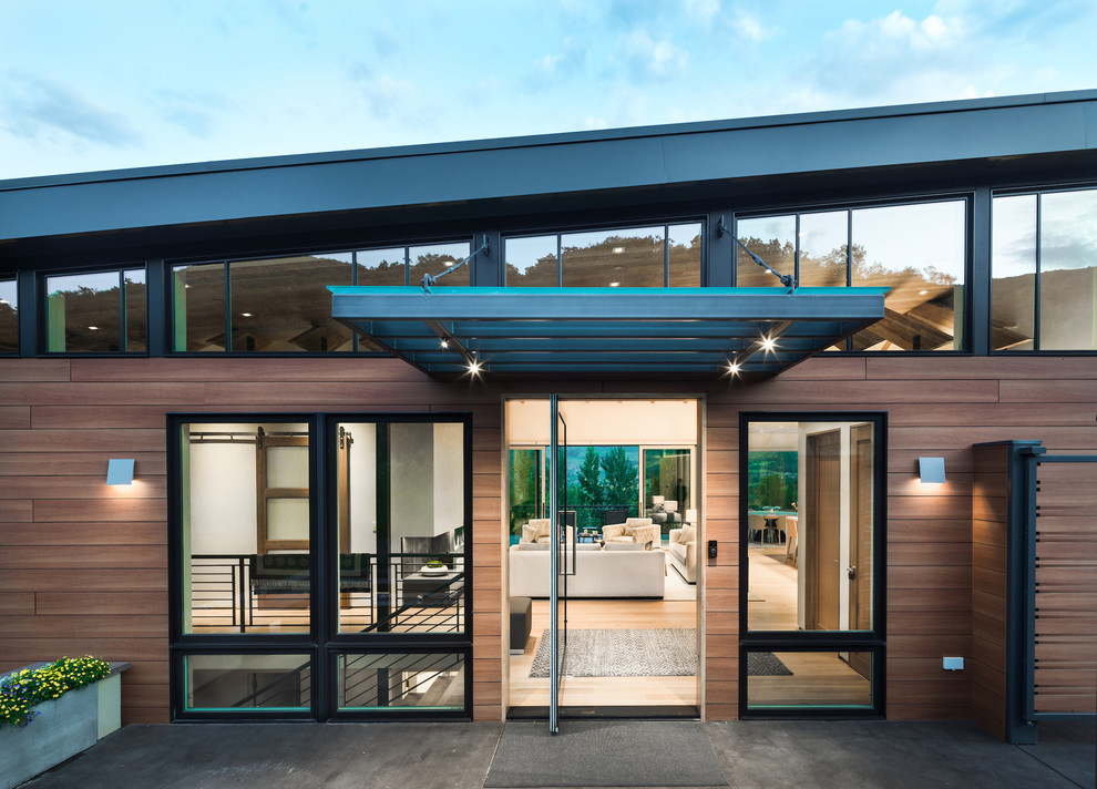 Foto de fachada de casa marrón minimalista grande de una planta con revestimiento de madera y tejado plano