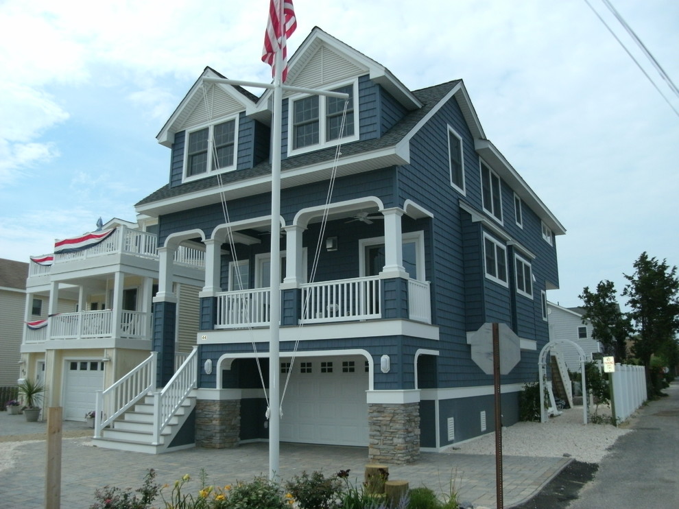 Стильный дизайн: трехэтажный, деревянный, синий частный загородный дом в морском стиле с вальмовой крышей и крышей из гибкой черепицы - последний тренд