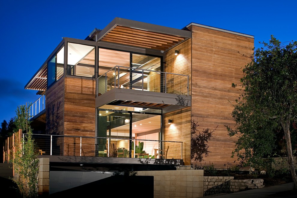 Imagen de fachada contemporánea de dos plantas con revestimiento de madera y tejado plano