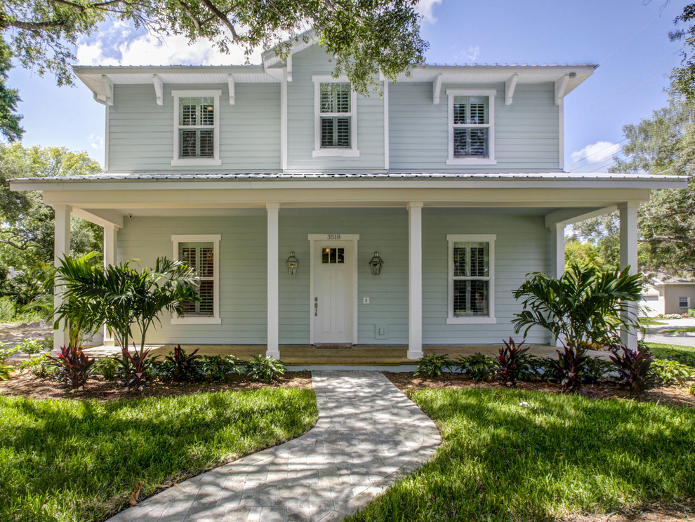 Large beach style blue two-story wood exterior home photo in Tampa with a hip roof