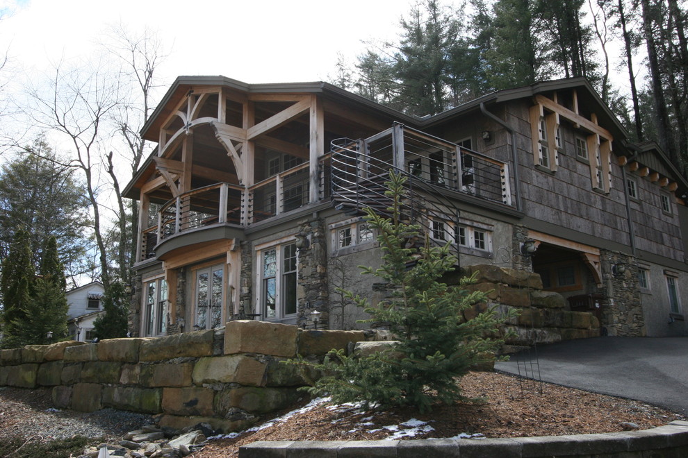 Modelo de fachada gris rústica de tamaño medio de tres plantas con revestimientos combinados y tejado a dos aguas