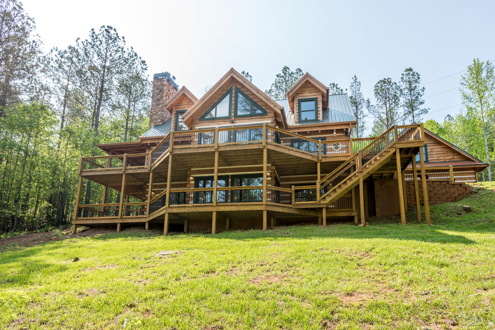 This is an example of a large and brown rustic two floor detached house in Atlanta with wood cladding, a pitched roof and a metal roof.