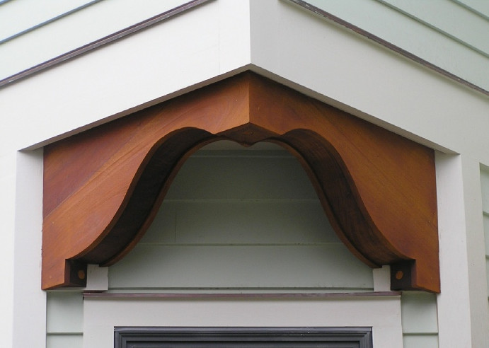 Cette image montre une petite façade de maison verte victorienne en bois à un étage avec un toit à deux pans.