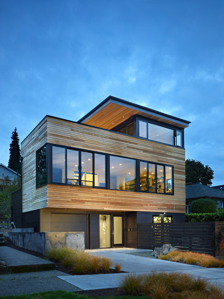 На фото: трехэтажный, коричневый дом среднего размера в современном стиле с комбинированной облицовкой и плоской крышей