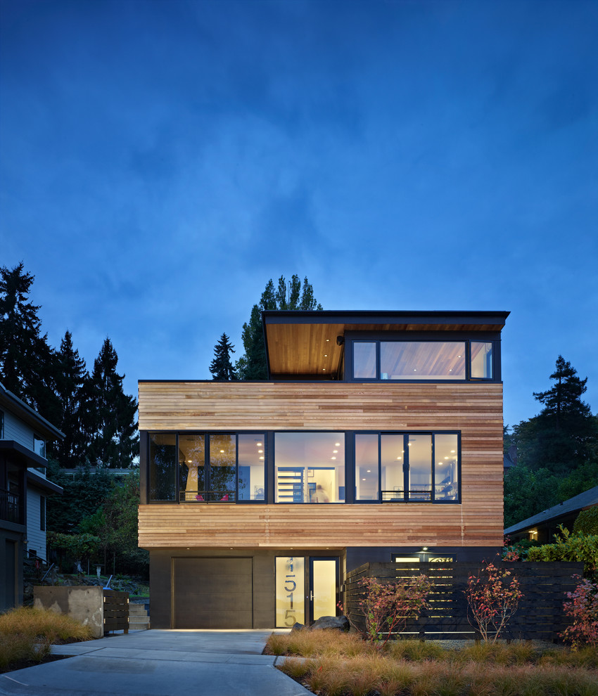 Exemple d'une façade de maison noire tendance en bois de taille moyenne et à deux étages et plus avec un toit plat.