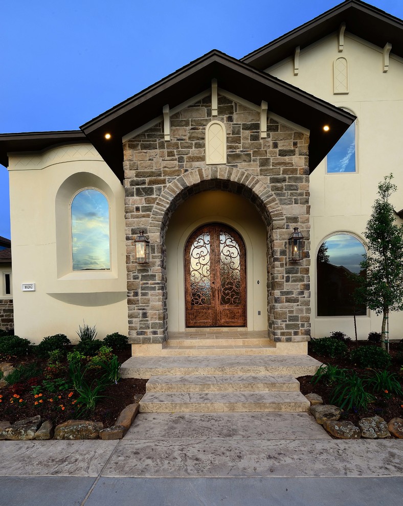Large tuscan beige two-story stucco house exterior photo in Houston with a hip roof and a shingle roof