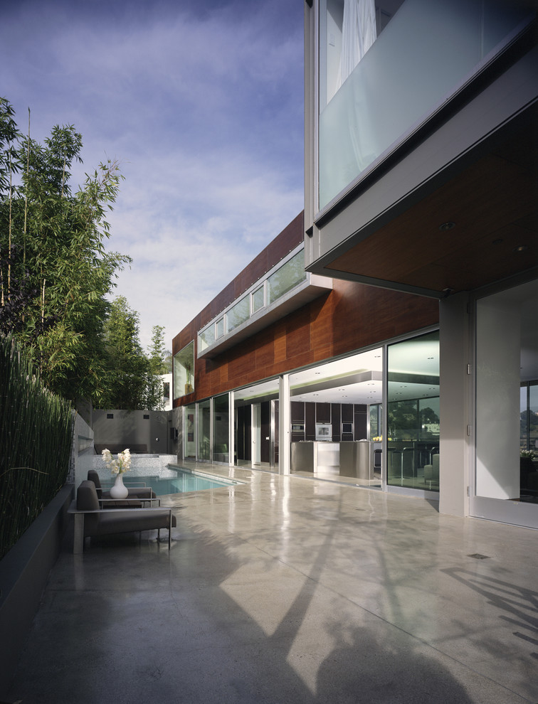 Design ideas for an expansive and brown modern two floor house exterior in Los Angeles with wood cladding and a flat roof.
