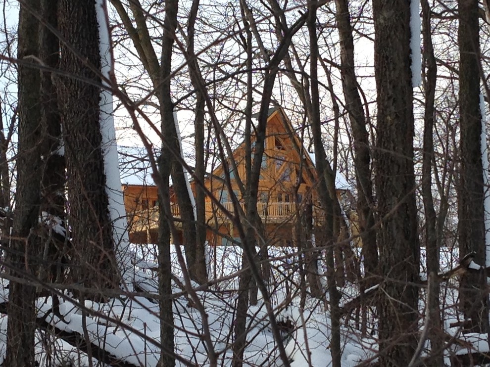 Cette image montre une façade de maison marron chalet en bois de taille moyenne et à un étage.
