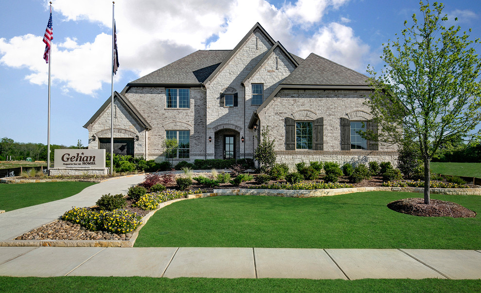 Example of a large gray two-story brick exterior home design in Dallas with a shingle roof