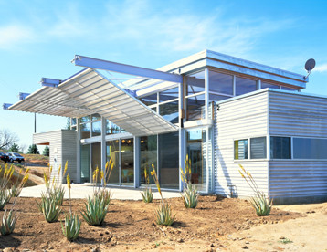 Imagen de fachada de casa moderna de una planta con revestimiento de metal y tejado plano