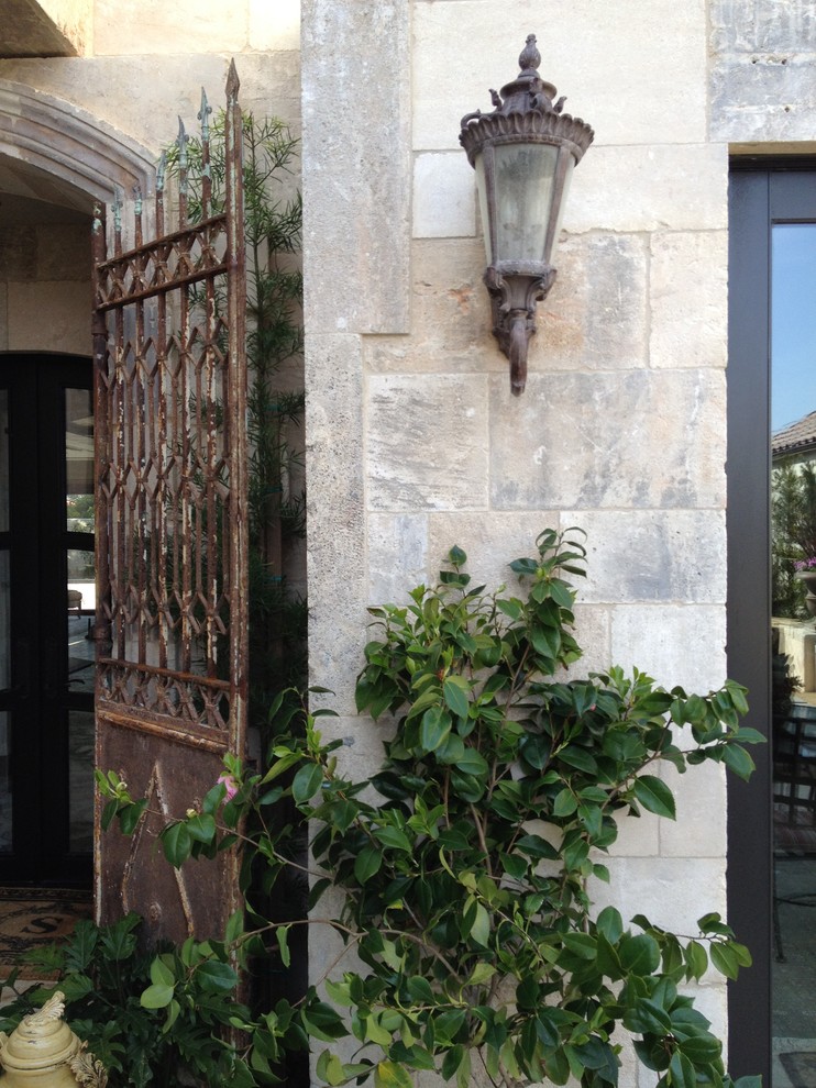 Ejemplo de fachada de casa mediterránea de tamaño medio de dos plantas con revestimiento de piedra
