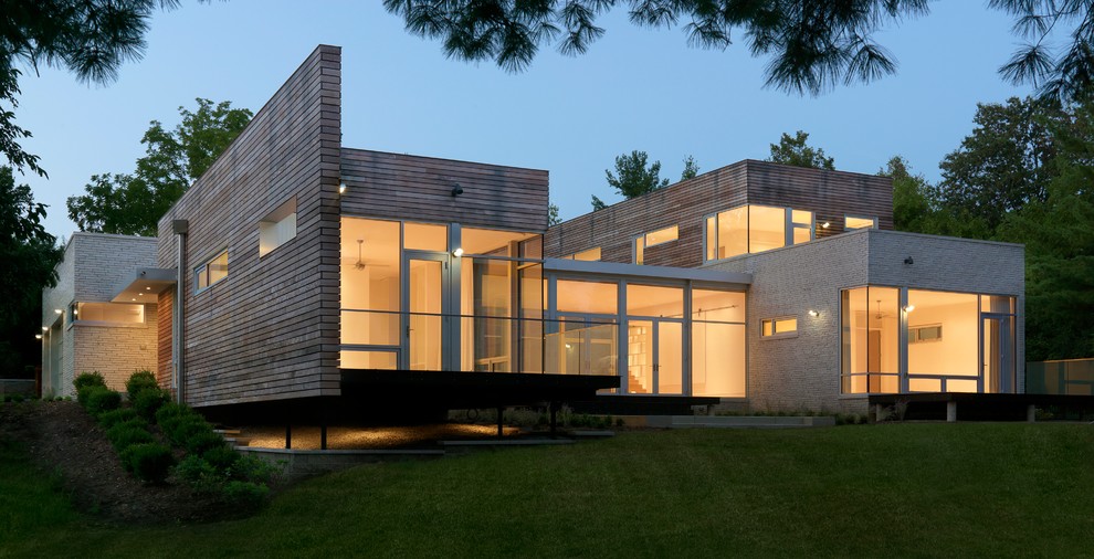 Imagen de fachada beige moderna de tamaño medio de dos plantas con revestimientos combinados y tejado plano