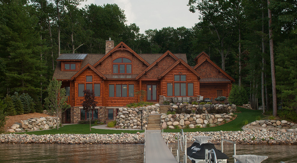 Large and brown rustic house exterior in Grand Rapids with three floors, wood cladding and a pitched roof.