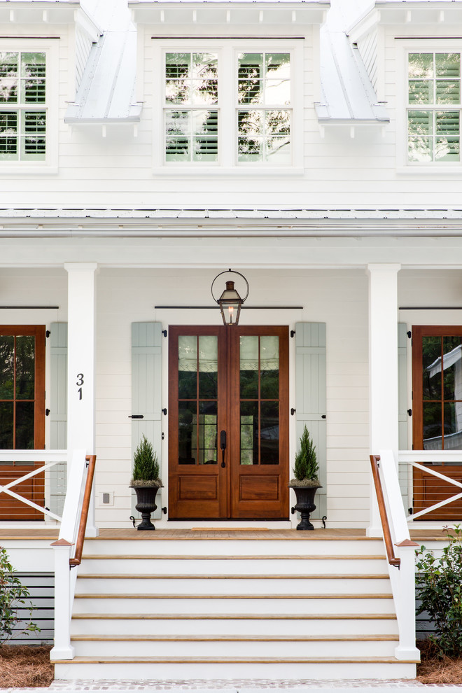 Example of a cottage white two-story wood exterior home design in Charleston with a metal roof
