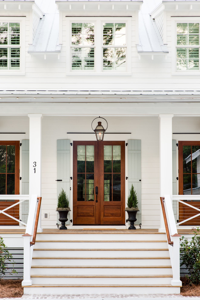 Cette image montre une façade de maison blanche rustique en bois à un étage avec un toit à deux pans et un toit en métal.