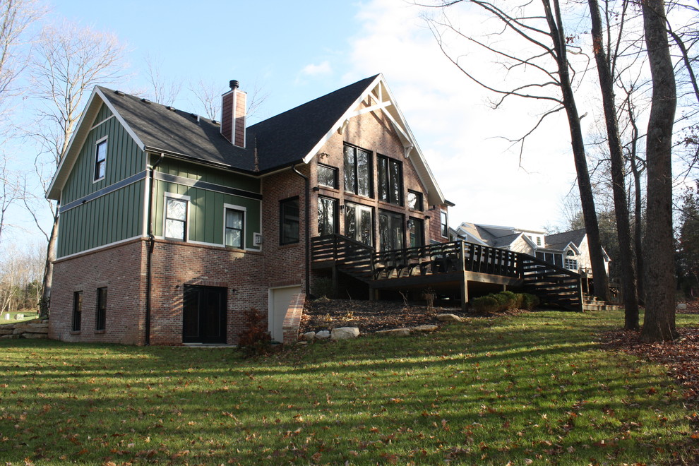 Cette photo montre une façade de maison verte nature en panneau de béton fibré de taille moyenne et à un étage avec un toit à deux pans.